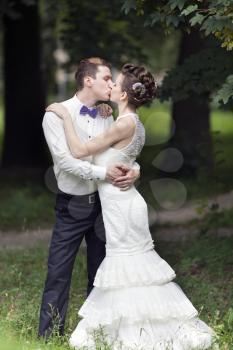 Just married couple kissing in the park
