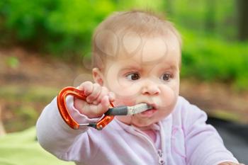 Baby girl eating climbing equipment quickdraw
