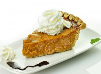 Slice of pumpkin pie with whipped cream on top 