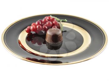 chocolate candy on a black plate on white background