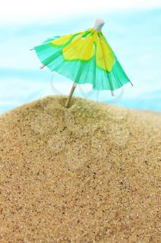 a cocktail umbrella on a beach sand