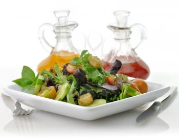 a fresh vegetable salad in a white dish with salad dressing