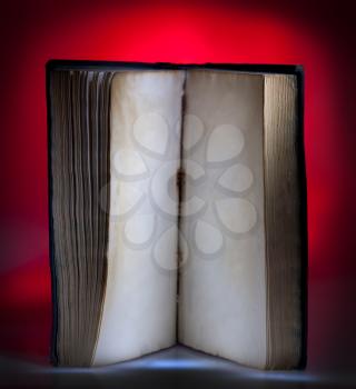 Open old book, mystical red light at background