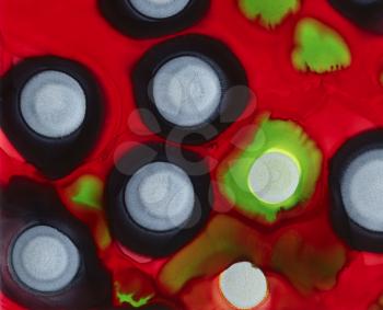 Black green silver spots on bright red.Colorful background hand drawn with bright inks and watercolor paints. Color splashes and splatters create uneven artistic modern design.