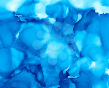 Blue and light blue paint uneven texture.Colorful background hand drawn with bright inks and watercolor paints. Color splashes and splatters create uneven artistic modern design.