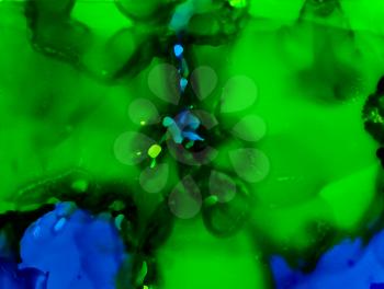 Green over blue paint flow.Colorful background hand drawn with bright inks and watercolor paints. Color splashes and splatters create uneven artistic modern design.