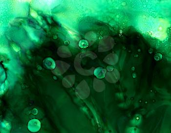 Deep green cloudy texture with light.Colorful background hand drawn with bright inks and watercolor paints. Color splashes and splatters create uneven artistic modern design.
