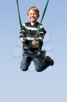 A happy child laughing on a swing