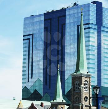 Royalty Free Photo of a Glass Building and Church Steeples