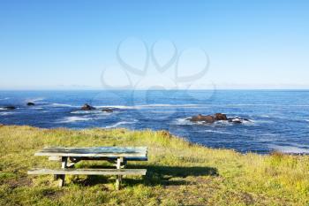 Royalty Free Photo of a Picnic Table Beside the Ocean