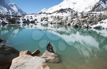 Royalty Free Photo of a Woman Resting Beside a Mountain Lake