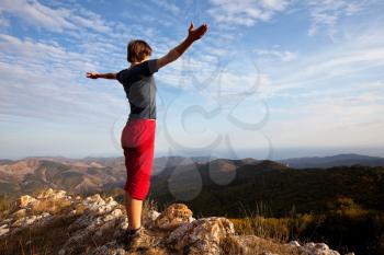 Royalty Free Photo of a Woman Standing on Top of a Mountain