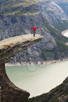 Royalty Free Photo of a Hiker on a Cliff in the Mountains of Norway