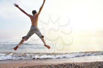 Royalty Free Photo of a Boy Jumping at the Beach