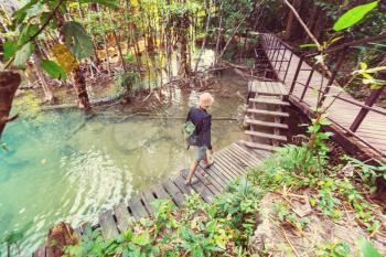 Wooden walkway in jungle along waterfalls in Thailand. Beautiful asian landscapes.