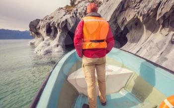 Tourist in boat tour to unusual marble caves on the lake of General Carrera, Patagonia, Chile. Carretera Austral trip.