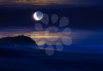 Full moon rising above ocean coast