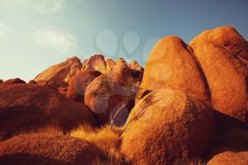 Colorful landscapes of the orange rocks in the Spitscoppe mountains in Namibia on a sunny hot day.