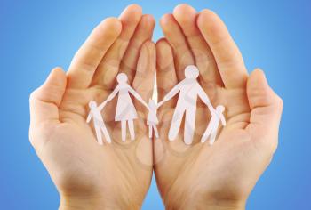 Paper family in hands isolated on blue background
