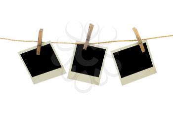 Three blank instant photos hanging on the clothesline. Isolated on white background.