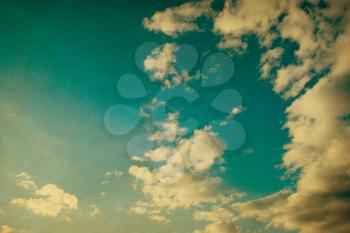 White clouds in blue sky in grunge and retro style.