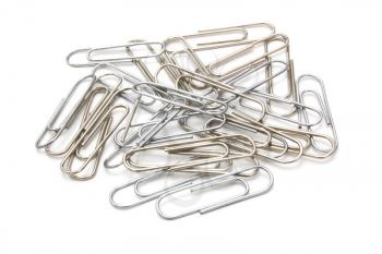 Writing metal paper clips lie in bulk on a white background of a paper