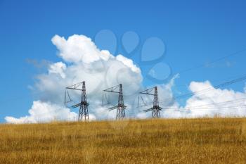 Three electrical towers  background of clouds and sky