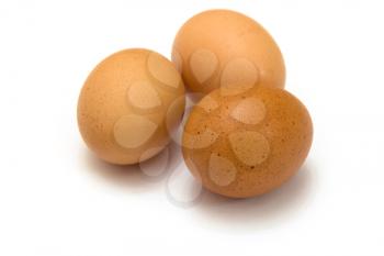 Three eggs lying down on a white linen background