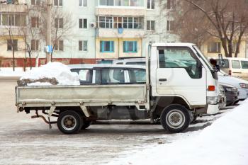 The small truck of white color with snow in a body