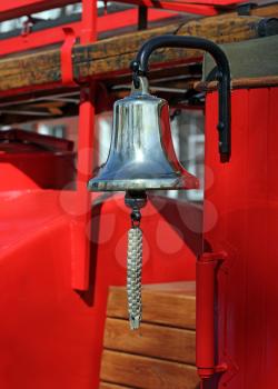 Metal alarm bell on red fire truck.
