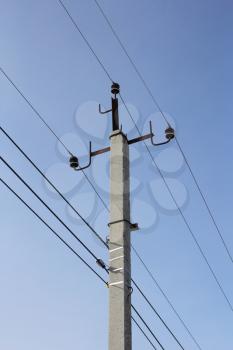 Concrete electric pole with wires against the sky
