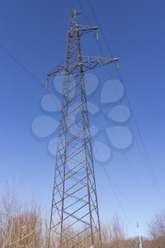 Concrete electric pole with wires against the sky