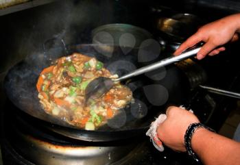Royalty Free Photo of a Person Stirring Food in a Wok