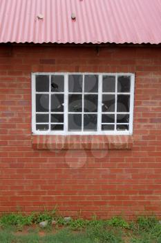 Royalty Free Photo of an Abandoned Red Brick Building with Broken Windows 