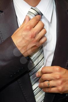 man hands remedying a tie