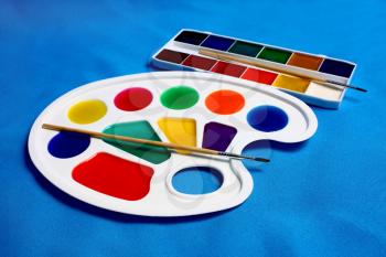 paints palette for drawing isolated on blue background