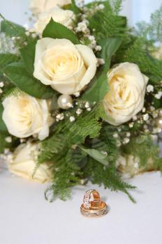 two gold wedding rings and bouquet