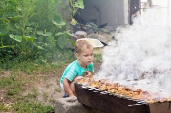 boy cooks barbecue
