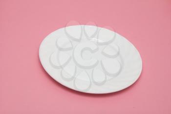 white plate on a pink background