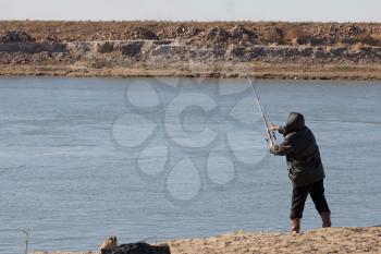 fisherman catching a fish on a fishing tackle in the river