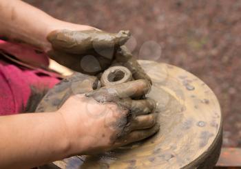 Potter hands making in clay on pottery wheel. Potter makes on the pottery wheel clay pot.