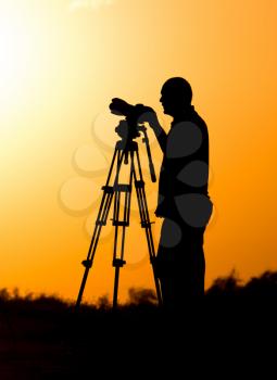 Man photographer with a camera at sunset .
