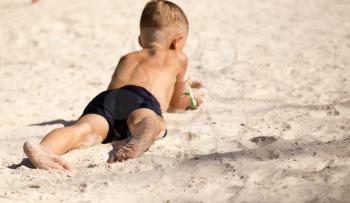 Feet of a boy playing in the sand .