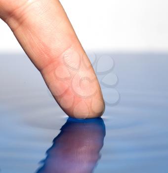 finger touches the water. macro