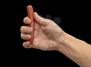 Sausage in a hand on a black background