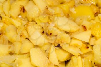 potatoes and onions in a frying pan as background