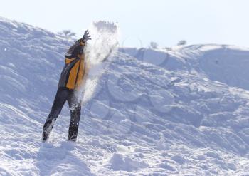 man throws snow in the winter