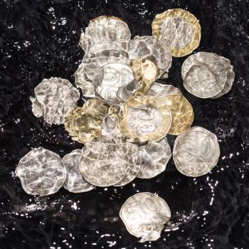 coins in water splashes on a black background