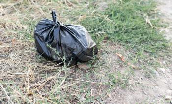 black bag of trash on the ground