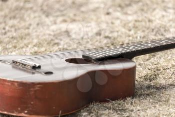 Guitar lying on the grass on the nature